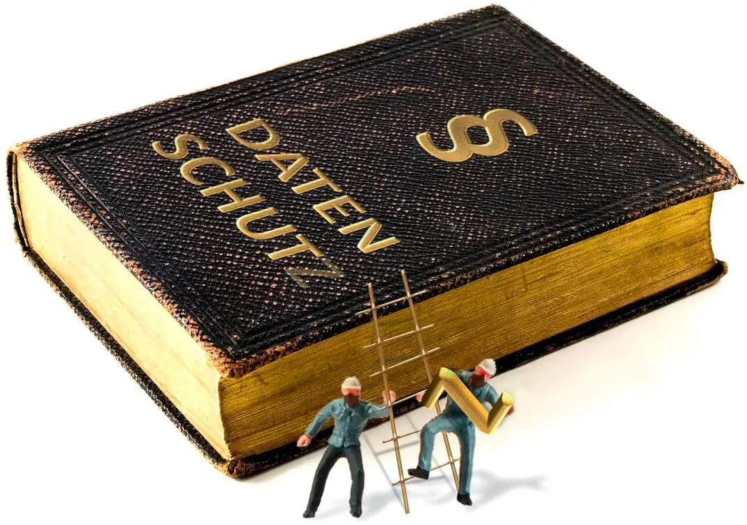 Buch mit 'Datenschutz', wobei Arbeiter das 'Z' entfernen